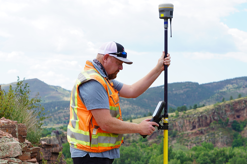 land surveyor using Trimble antenna and data collector outdoors