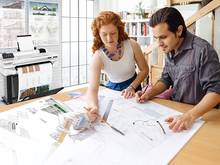 man and woman overlooking large print plans