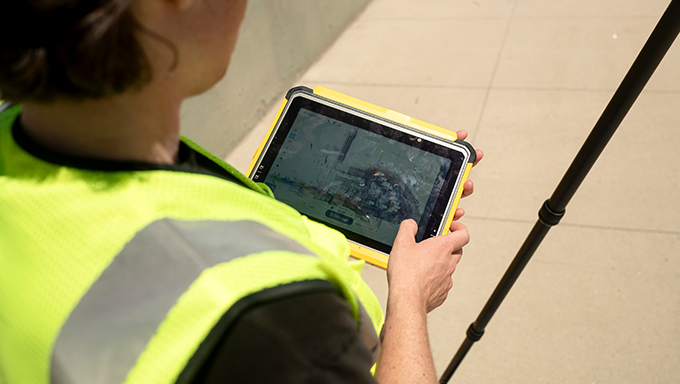 surveyor holding t110 near total station tripod