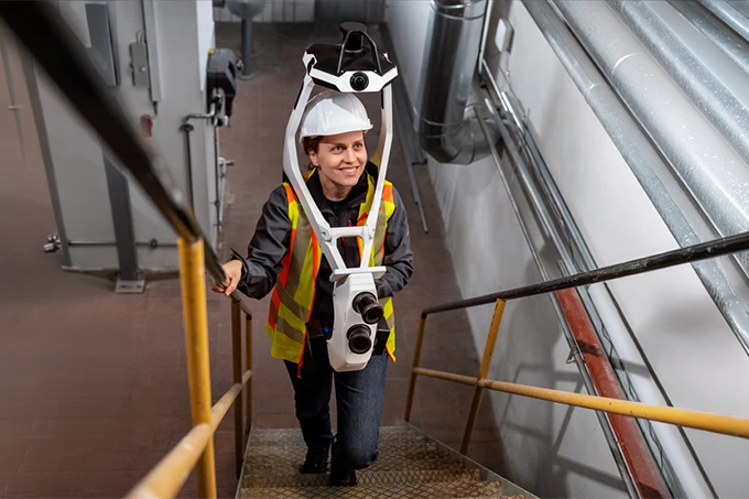 field worker using NavVis VLX 4 inside utility room walking up stairs