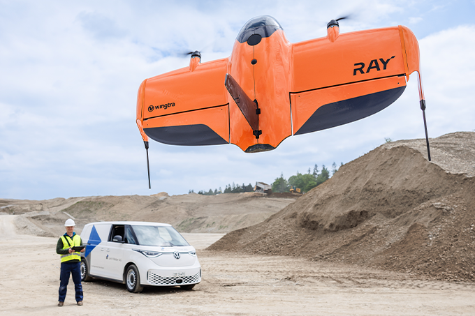 WingtraRAY flying in the air as field working operates with remote