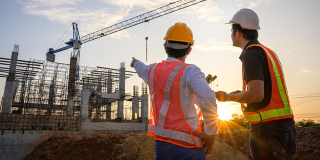 two engineers at construction site during sunrise