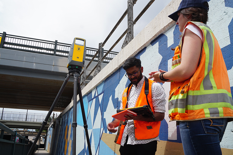 two field workers in urban city using GNSS total station