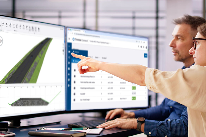 engineers looking at 3D render on two computer screens