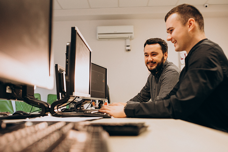 two men in front of computer